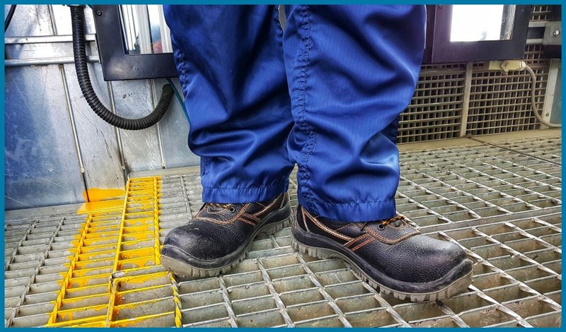 A big guy using work shoes for protection accidents in the factory